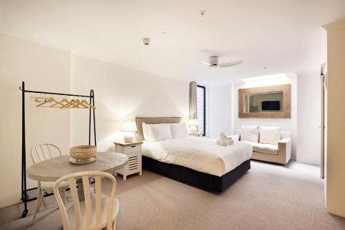 a bedroom with a bed and a table and a chair at Queen Bed Studios with Sofa at Manly - 3min walk to Corso & Manly Beach in Sydney