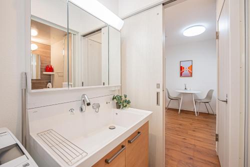 un baño con lavabo y espejo en U Stay 西川口, en Kawaguchi