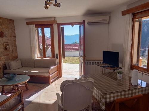 a living room with a couch and a television at pavliani house in Pávliani