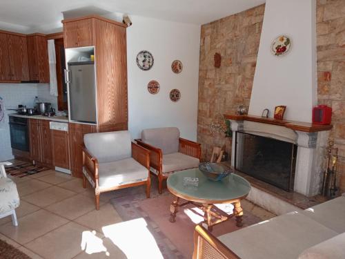 a kitchen with a living room with a fireplace at pavliani house in Pávliani