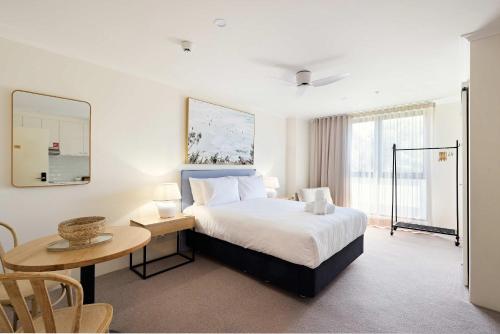 a hotel room with a bed and a table and a table sidx sidx at Queen Studios with Sofa Bed at Manly - 3min walk to Corso & Manly Beach in Sydney