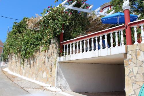 a retaining wall with plants on it next to a street at Villa PANGALIS Romantica in Kato Pavliana