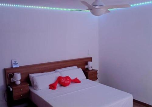 a bedroom with a white bed with red pillows at Apartalux San Pedro Ático de Luna in San Pedro del Pinatar