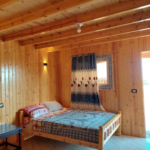a bedroom with a bed in a wooden room at Shakazola Camp in Nuweiba