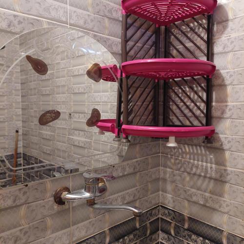 a bathroom with a pink chair on the wall at Shakazola Camp in Nuweiba