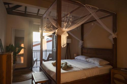 a canopy bed in a bedroom with a balcony at Bakamuna Villa in Dickwella