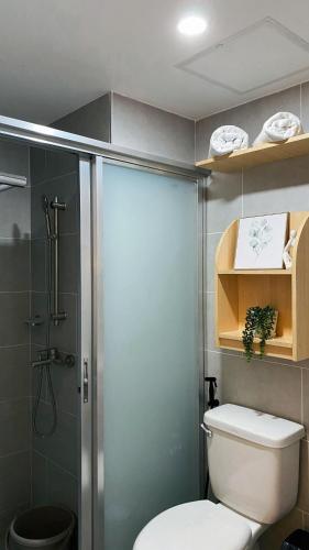 a bathroom with a toilet and a glass shower at Cozy Nook at JTower Residences in Mandaue City