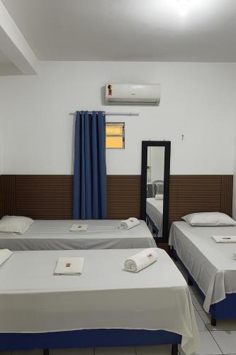 zwei Betten in einem Zimmer mit einem Spiegel in der Unterkunft Pousada Executiva in Teresina