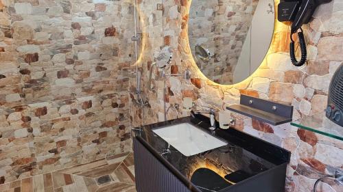 een badkamer met een wastafel en een spiegel bij l'oasis de paix refugee unique à Marrakech in Aït Amara