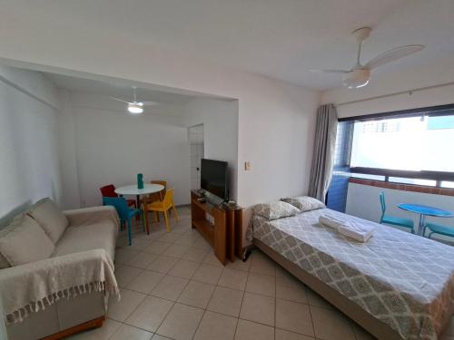 a bedroom with a bed and a couch and a table at Ap Orla de Aracaju in Aracaju