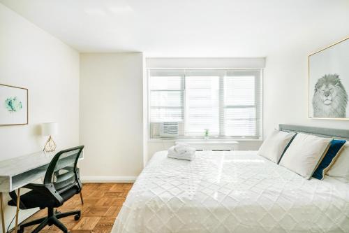 ニューヨークにあるLovely and Comfy Studio in NYCのベッドと机のある白い寝室