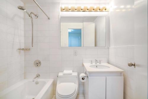 ニューヨークにあるLovely and Comfy Studio in NYCのトイレと洗面台を備えた白いバスルーム