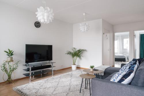 een woonkamer met een bank en een tv bij Spacious City Retreat with Private Sauna in Helsinki
