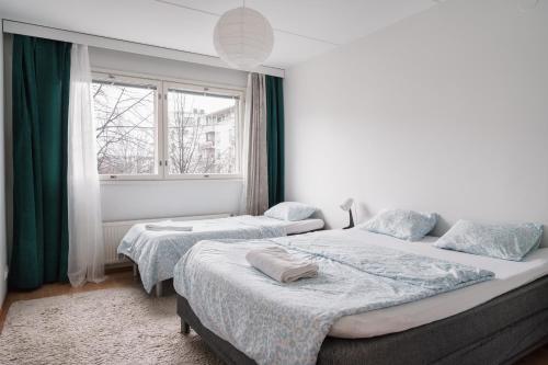een slaapkamer met twee bedden en een raam bij Spacious City Retreat with Private Sauna in Helsinki