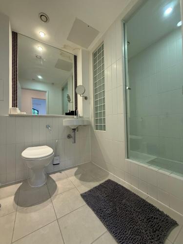 a bathroom with a toilet and a glass shower at Modern 2 Bedroom Apartment in Kings Cross, London, N1 in London
