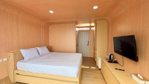 a bedroom with a bed and a flat screen tv at The Lakebox Menjer by Travelink in Garung