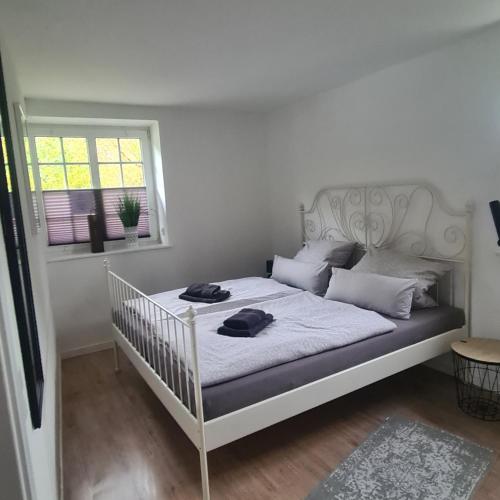 una cama blanca con dos sombreros encima en un dormitorio en Haus hinter dem Deich, en Simonsberg