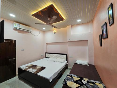 Un dormitorio con una cama y un ventilador de techo. en Shri Mahaveer Residency, en Ayodhya