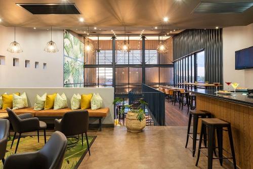 ein Restaurant mit einer Bank und Tischen und Stühlen in der Unterkunft Kathu Hotel in Kathu