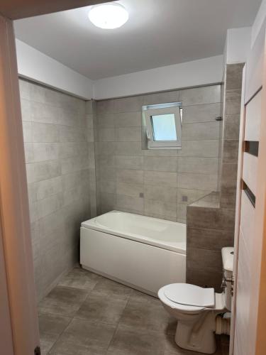 a bathroom with a white tub and a toilet at illy apartament in Craiova