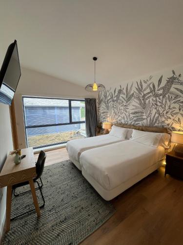 a bedroom with a large bed and a large window at HOTEL CASAS DA FORTALEZA Casa da Solaina in Outeiro de Rei