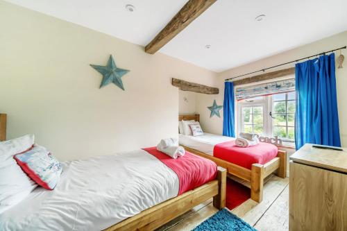 a bedroom with two beds and a window at Sunset View in Thornham