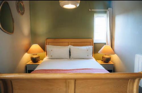 a bedroom with a bed with two lamps on tables at The Hideaway in Stratford-upon-Avon