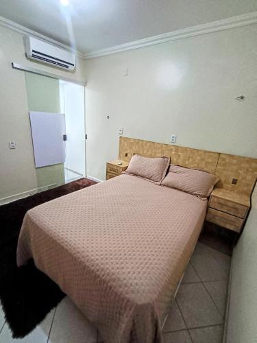 ein Schlafzimmer mit einem Bett mit einer braunen Bettdecke in der Unterkunft Apto inteiro 3 quartos, sendo duas suítes in Belém