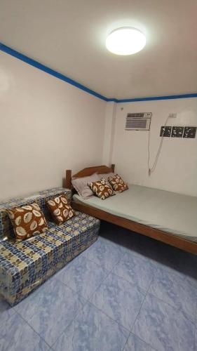 En eller flere senge i et værelse på Blue House - Cozy 1BR in General Luna