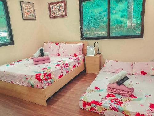 a bedroom with two beds with pink flowers on them at Insta-Worthy Swiss House Crosswinds Tagaytay in Tagaytay