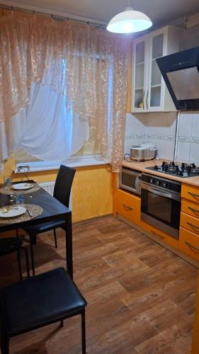 a small kitchen with a table and a stove at Апартаменти біля Автовокзалу in Kryvyi Rih