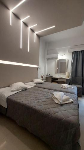 ein Schlafzimmer mit einem großen Bett und Wandleuchten in der Unterkunft Mantas Hotel in Loutraki