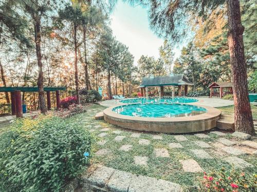 a swimming pool in a park with a gazebo at Insta-Worthy Swiss House Crosswinds Tagaytay in Tagaytay
