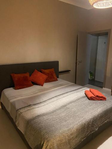 a bed with orange pillows on it in a room at La Nonne Blanche in Ostend