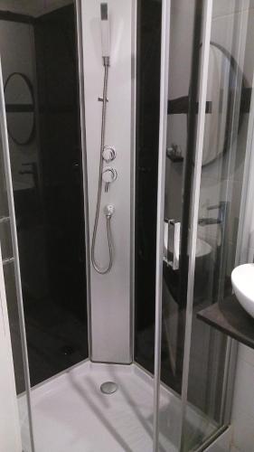 a shower with a glass door in a bathroom at La Nonne Blanche in Ostend