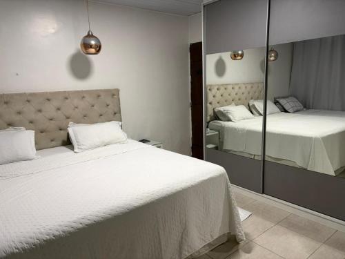 a bedroom with two beds and a mirror at Grande casa para COP30 perto do parque da cidade in Belém