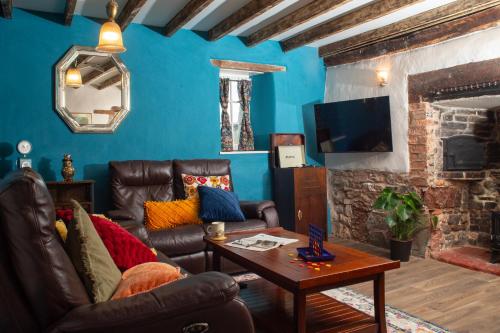 a living room with a couch and a table at Snowdrop Cottage in Jacobstowe