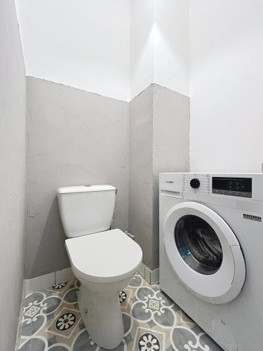 a bathroom with a toilet and a washing machine at Duplex de la place de Bergues in Bergues