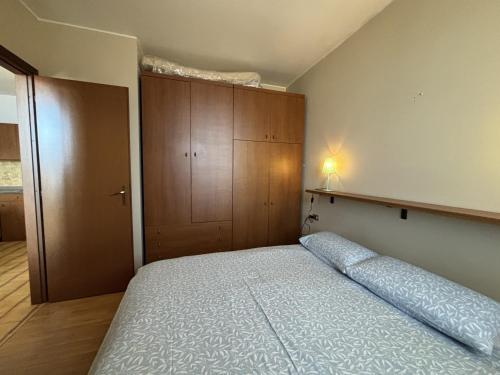 a bedroom with a bed and a wooden cabinet at Graziella 1 in Germignaga