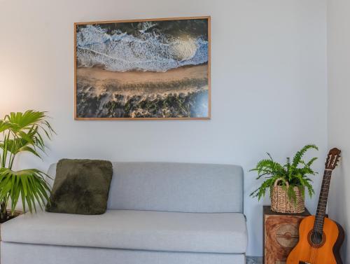 a living room with a blue couch and a guitar at Layback on Marine in Kingscliff