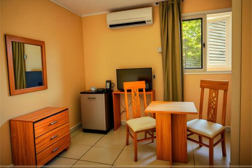 a living room with a table and a television at Pyramids & SphinX Grand Hotel in Cairo