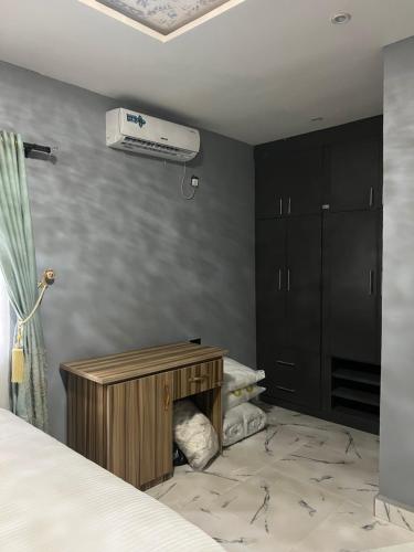 a bedroom with a bed and a chest of drawers at GG suites and Apartments in Owerri