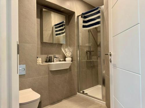 a bathroom with a shower and a toilet and a sink at Harbour View - Steps From The Sea - Balcony - Parking in Ramsgate