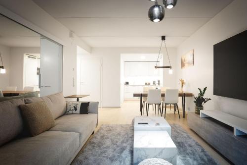 a living room with a couch and a table at Cozy Seaside Apt near Helsinki Harbour -Jätkäsaari in Helsinki