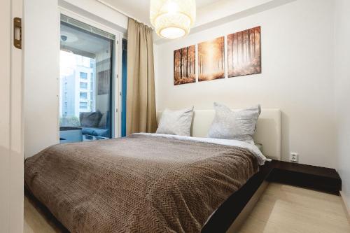 a bedroom with a bed with a picture on the wall at Cozy Seaside Apt near Helsinki Harbour -Jätkäsaari in Helsinki