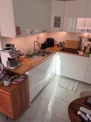a kitchen with white cabinets and a sink at Cozy personal flat in Differdange in Differdange