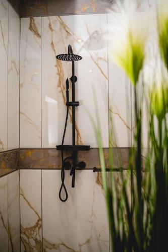 a wall mounted shower gun in a bathroom with flowers at Santareme Breeze in Sea Vista