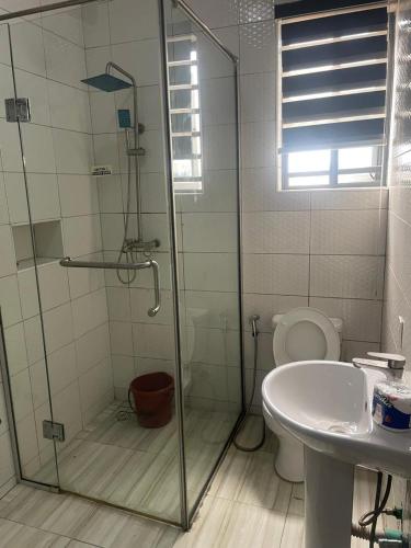 a bathroom with a shower and a toilet and a sink at Abiluxe in Hausa