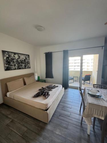 a bedroom with a bed and a table and a dining room at SGC Boa Vista Apartments in Sal Rei