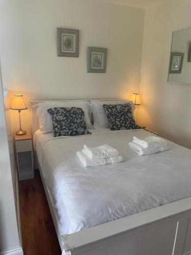a bedroom with a white bed with two towels on it at The Free Range Room at The Cracked Hen in Gorey